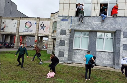 Studenten springen während der Schießerei aus dem Fenster der Universität in Perm. Foto: dpa/Alexey Romanov