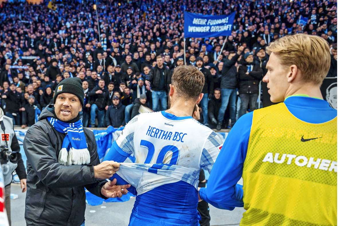 Ein Vertreter der Ultras fordert Hertha-Spieler Lucas Tousart auf, das Trikot auszuziehen. Foto: Imago// Wiedensohler
