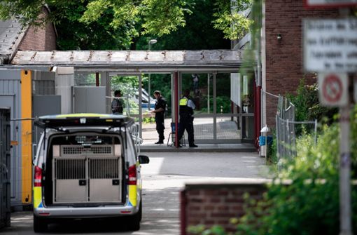 Polizisten mit Sprengstoff-Spürhunde durchsuchen die zwei betroffenen Schulen. Foto: dpa/Fabian Strauch