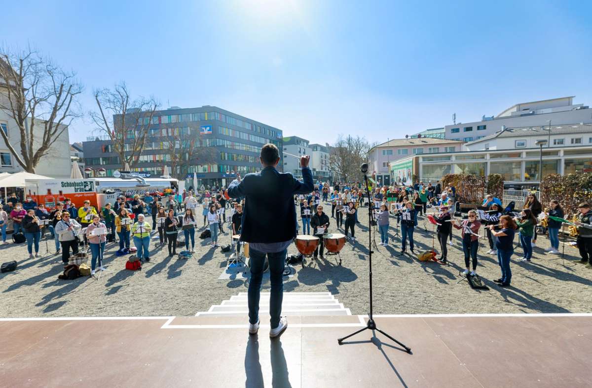 Markus Nau dirigiert ein kurzfristig geformtes  Blasorchester bei einem Solidaritätskonzert für die Ukraine auf dem „Grünen Platz“ in Sindelfingen.