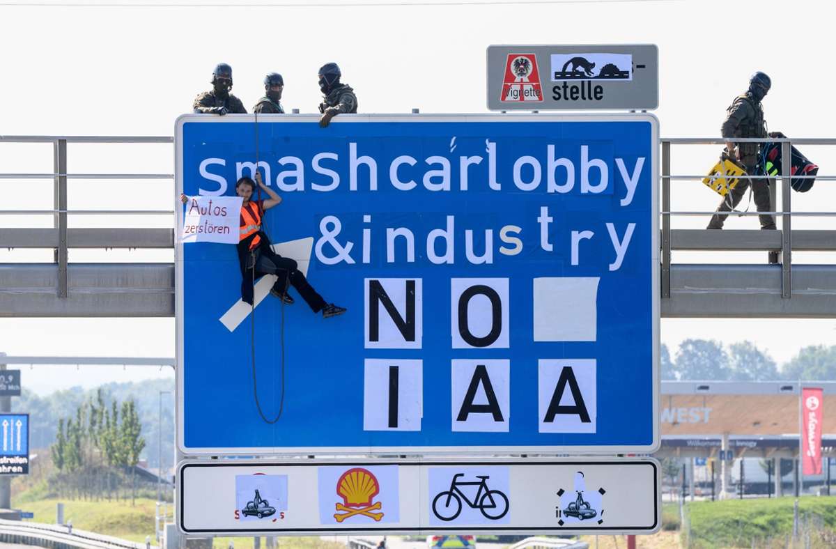 Ein Aktivist hängt bei einer Banneraktion an einer Schilderbrücke über der Autobahn A9 bei Fürholzen in Fahrtrichtung München. Foto: dpa/Matthias Balk