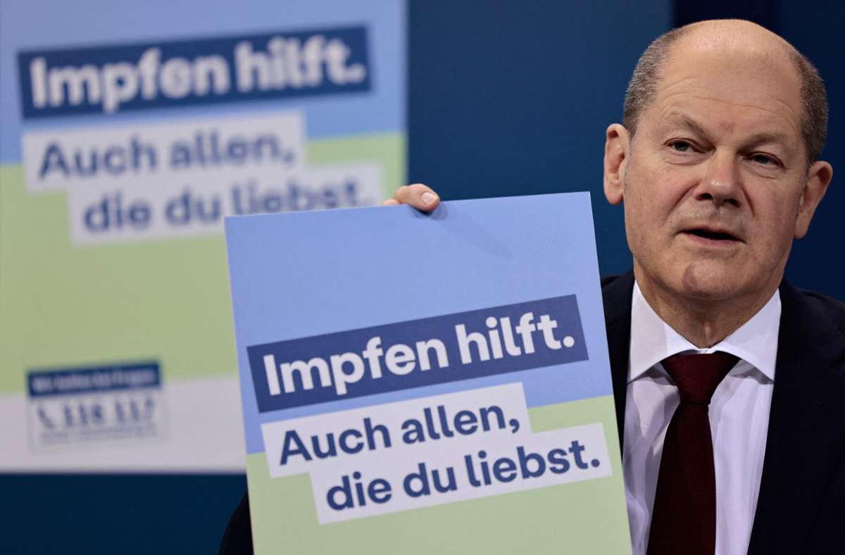 Bundeskanzler Olaf Scholz (SPD) präsentiert ein Plakat für eine neue Impfkampagne während einer Pressekonferenz nach einem Treffen im Kanzleramt. Foto: AFP/Hannibal Hanschke
