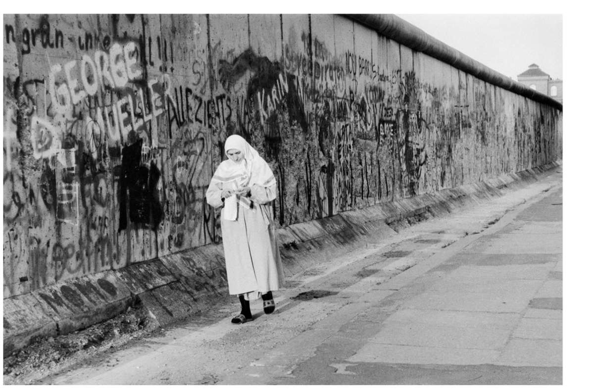 Vom Westen aus gesehen eine Art Leinwand mit Spazierweg: Dieses Foto von Sibylle Bergemann entstand 1989, in dem Jahr, in dem die Mauer fiel. Die Mauer war zu diesem Zeitpunkt für viele Berliner eine Kulisse ihres Alltags.