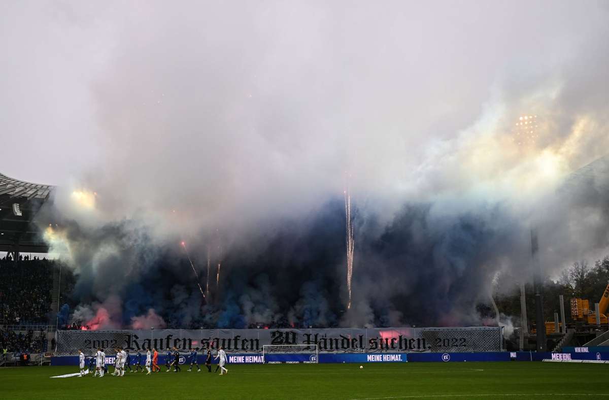 Karlsruher Fans hüllen die Tribüne beim Spiel gegen den FC St. Pauli am 12. November 2022 in dichten Rauch. Foto: imago
