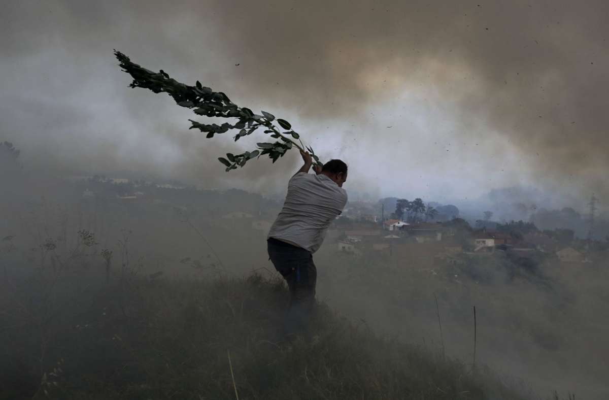 Die Menschen versuchen die Flammen von ihren Häusern fernzuhalten – wie hier in der Nähe von Leiria in Portugal.