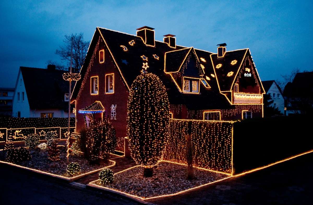 Das sogenannte Lichterhaus der Familie Pingel in Dortmund strahlt vor dem dunkelblauen Abendhimmel.