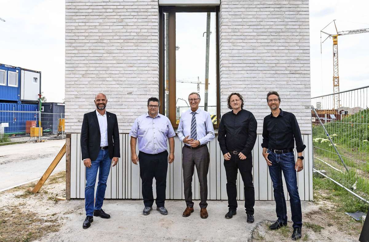 Bauherren, Planer und Architekten vor einem Muster der Klinkerfassade Foto: Eibner/Roger Bürke
