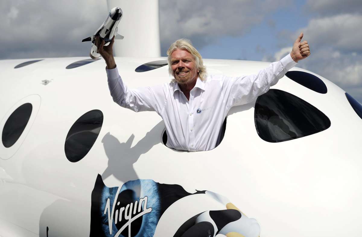 Der britische Geschäftsmann Sir Richard Branson posiert für Fotografen im Schaufenster einer Replik der Virgin Galactic, der weltweit ersten kommerziellen Raumfahrtlinie.