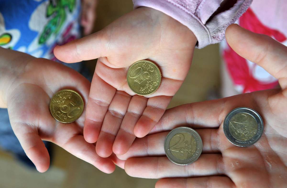 Drei Kinder halten ihr Taschengeld in den Händen. Foto: dpa/Patrick Seeger