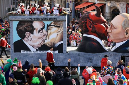 Der Mottowagen „Verkörperte Zitate“ mit einer Darstellung des russischen Präsidenten Putin der den Teufel küsst, fährt in Köln im Festumzug mit. Foto: dpa/Oliver Berg