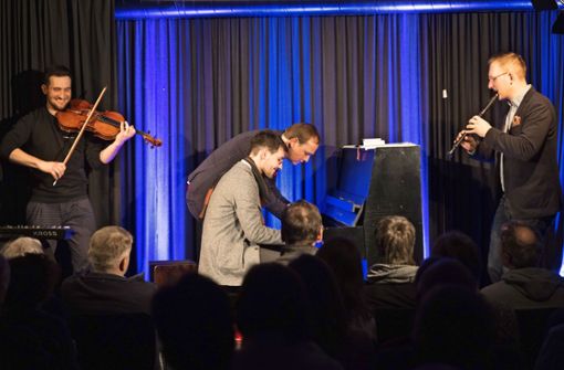 Musikkabarettist Christoph Reuter (gebeugt) spielt vierhändig mit Jonathan Hanke Klavier, die  Brüder David und Lukas Hanke begleiten auf Flöte und Bratsche. Foto: Stefanie Schlecht