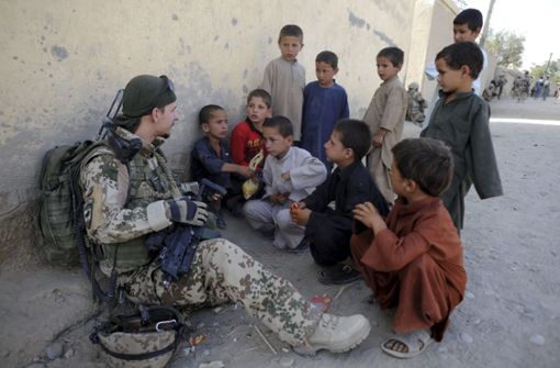 Ein Soldat der Bundeswehr mit afghanischen Kindern. Foto: dpa/Maurizio Gambarini