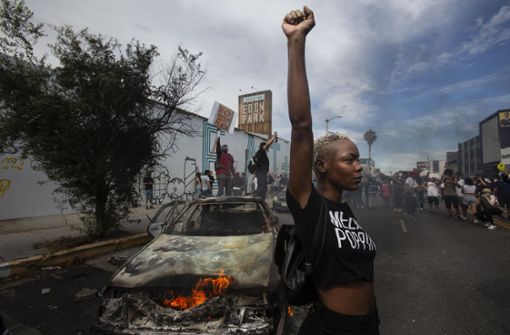 Eine Demonstrantin in Los Angeles hebt neben einem brennenden Polizeifahrzeug ihre Faust in die Luft während einer Demonstration gegen Rassismus nach dem Tod von George Floyd. Das Bild war Teil einer Fotoserie von The Associated Press (AP), die mit dem Pulitzer-Preis ausgezeichnet wurde. Foto: dpa/Ringo H.W. Chiu