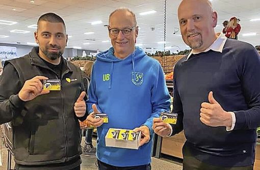 Marktleiter Illkay Özelik (links) und Vertriebsleiter Markus Kästner (rechts) bei der Übergabe der Karten an Uwe Bengel Foto: TSV