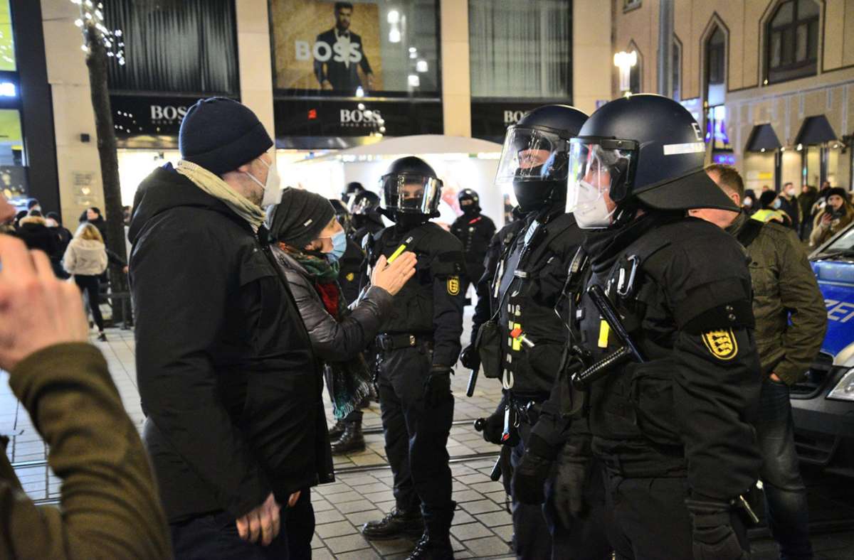 Leute in der Mannheimer Innenstadt sprechen während einer Corona-Demonstration Polizisten an. Foto: dpa/René Priebe