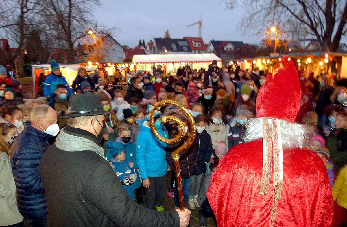 Eskortiert von Ortsvorsteher Volker Goldmann, begrüßt der Nikolaus die Kinder in Neuweiler. Foto:  