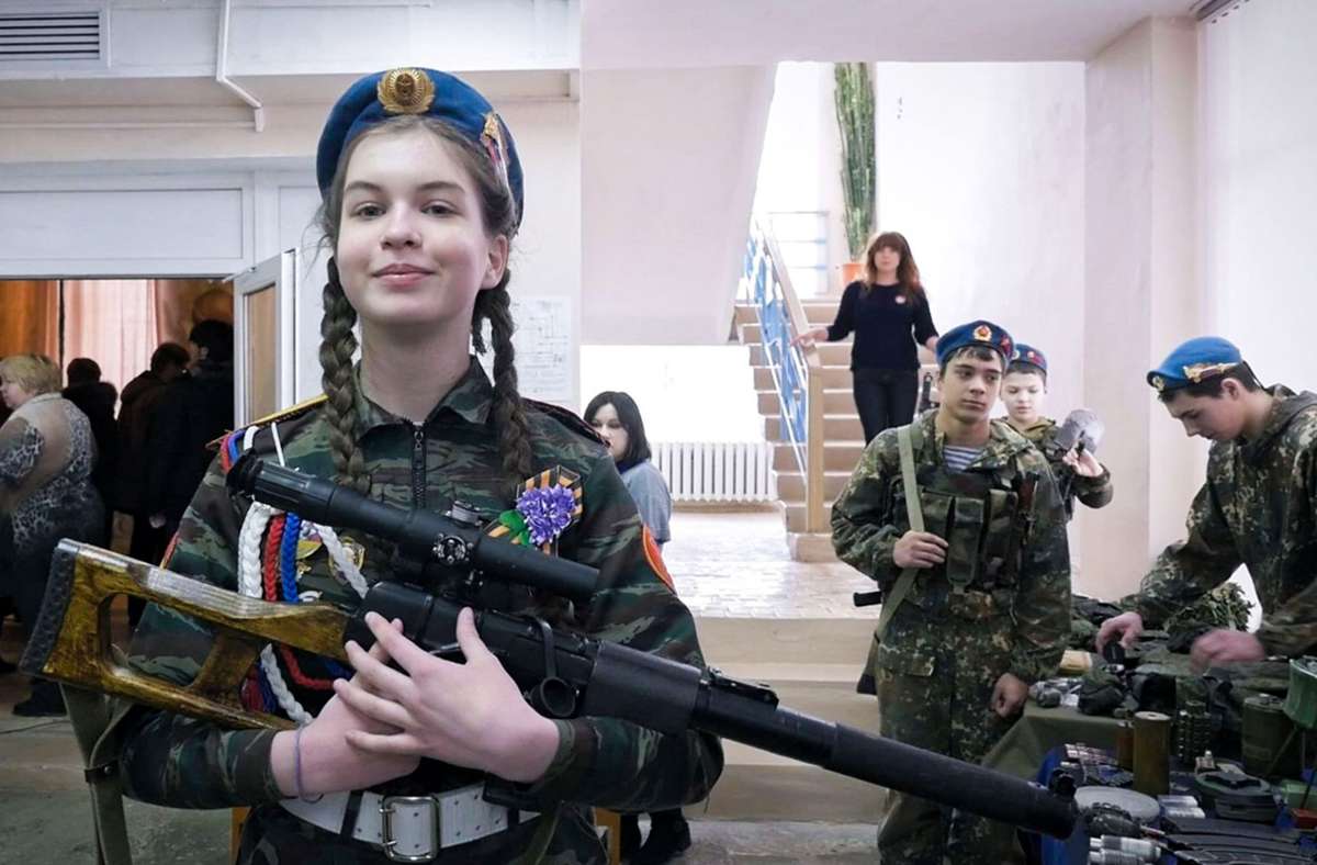 Die 16-jährige Mascha in Uniform und mit Gewehr: ganz normaler Teil einer militaristischen Früherziehung von Kindergartentagen an.