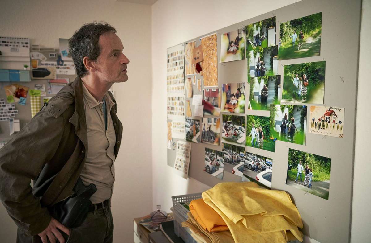 Kommissar Peter Faber (Jörg Hartmann) betrachtet in der Wohnung eines Verdächtigen Fotos.