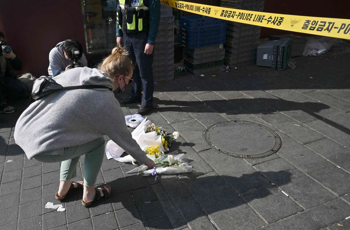 Menschen legen am Unglücksort Blumen für die Opfer nieder.