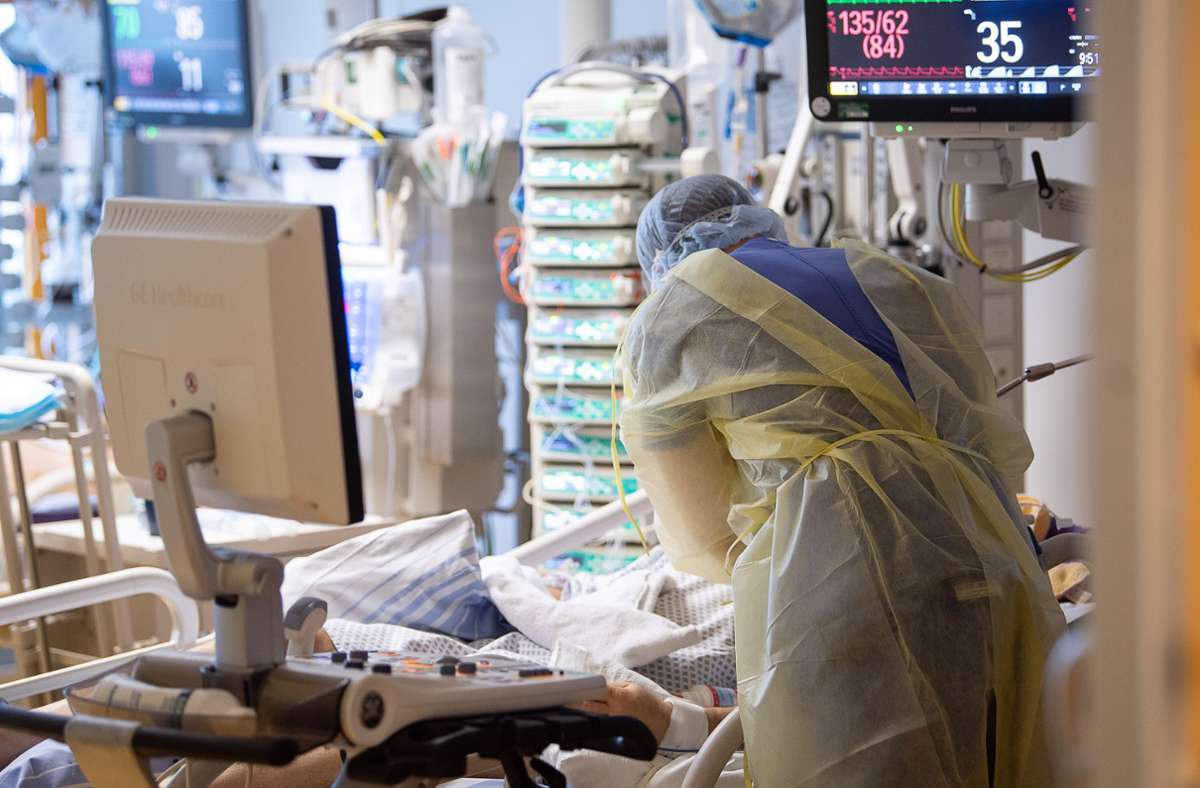 Ein Intensivpfleger arbeitet auf einer Intensivstation des RKH Klinikum Ludwigsburg an einem Covid-19-Patienten. (Archivbild) Foto: dpa/Sebastian Gollnow
