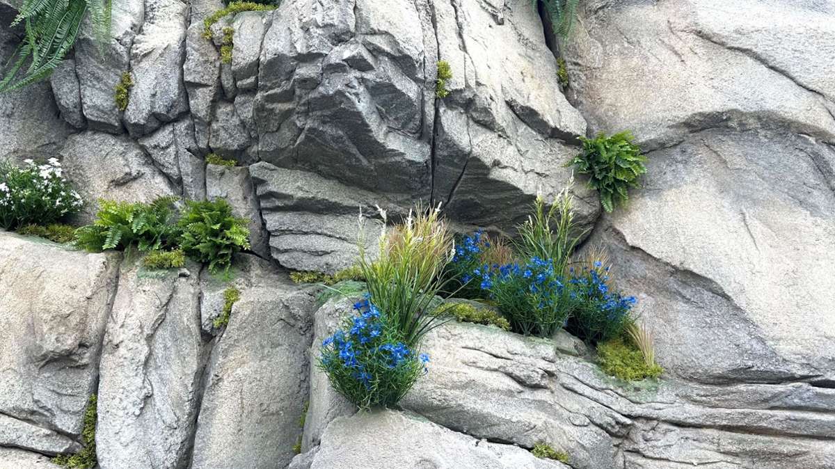 Künstliche Felsen und Blumen sollen das alpine Gefühl an der Bahn vermitteln.