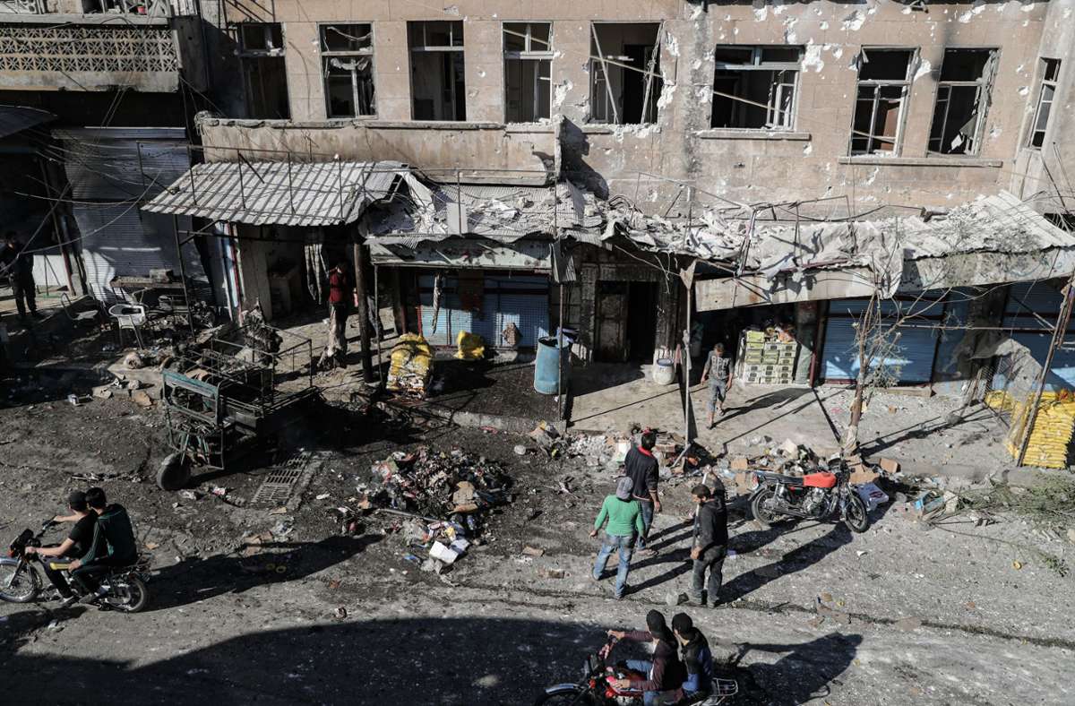 Syrer begutachten die Trümmer eines Ortes, der von einem Raketenbeschuss in Ariha betroffen war. Foto: dpa/Anas Alkharboutli