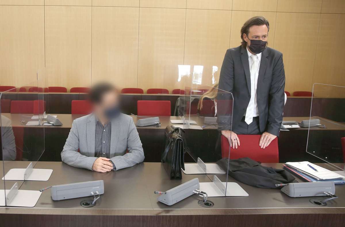Der angeklagte Arzt sitzt mit Maske im Gerichtssaal neben Verteidiger Rechtsanwalt Michael Noll vor seinem Prozess in Düsseldorf. Foto: dpa/David Young