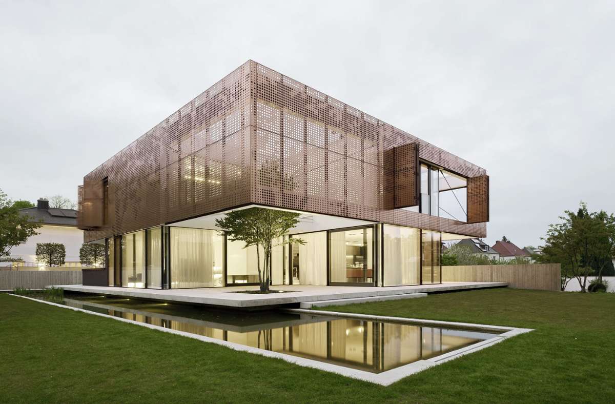 Wohnhaus mit Kupfervorhang über dem verglasten Erdgeschoss, geplant von Architekt Bernd Liebel. Dazu ein japanischer Kuchenbaum und ein Koi-Teich.