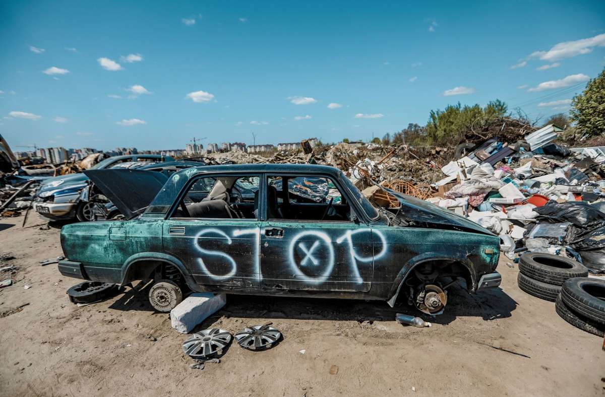 „Stop“ ist auf einem zerstörten Auto zu lesen, das auf einer Deponie im ukrainischen Butscha steht. Wann der Krieg endet, ist völlig offen. Foto: dpa/Aziz Karimov