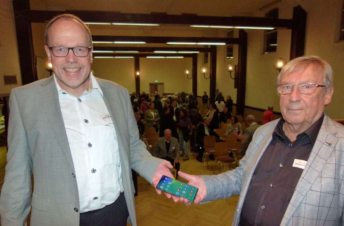 Gerhard Frech (rechts) übergibt „Bürger für Bürger“-Vorsitz und Dienst-Handy an seinen Nachfolger Dieter Renken. Foto: Holger Schmidt