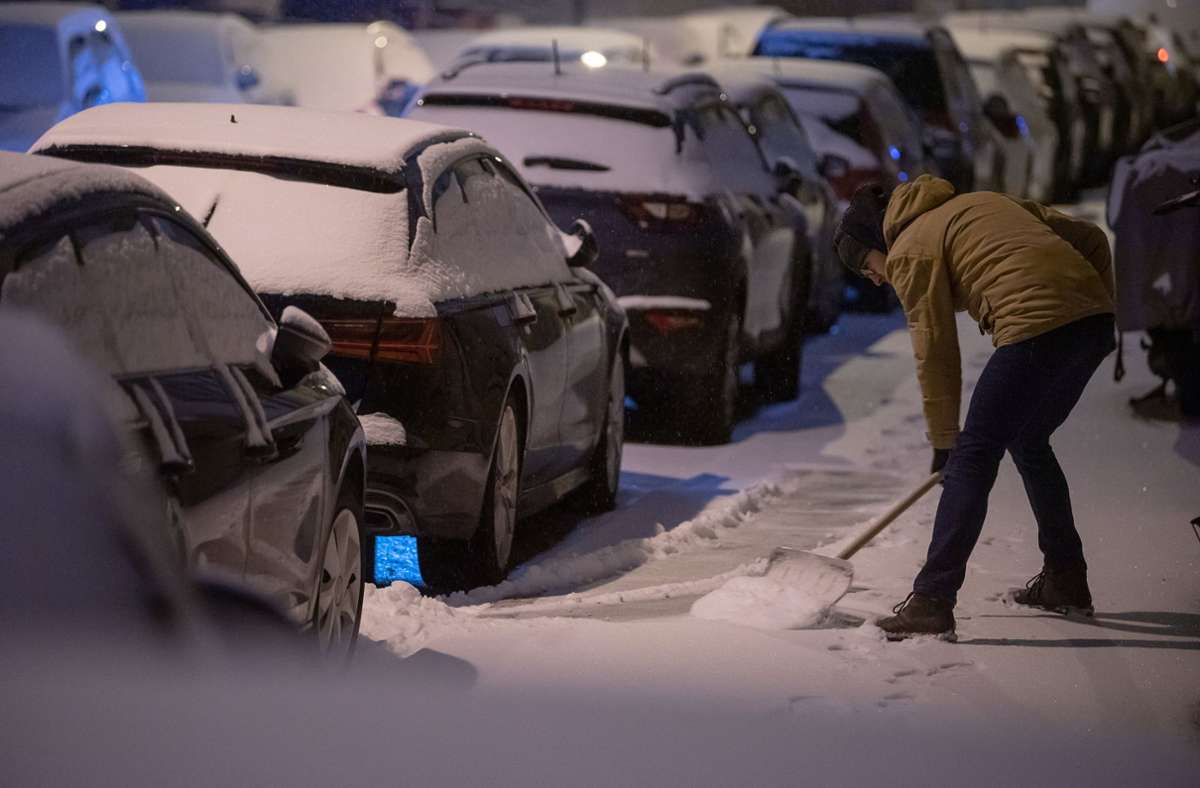 Stuttgart: Ein Mann schippt Schnee vom Bürgersteig. Foto: dpa/Sebastian Gollnow