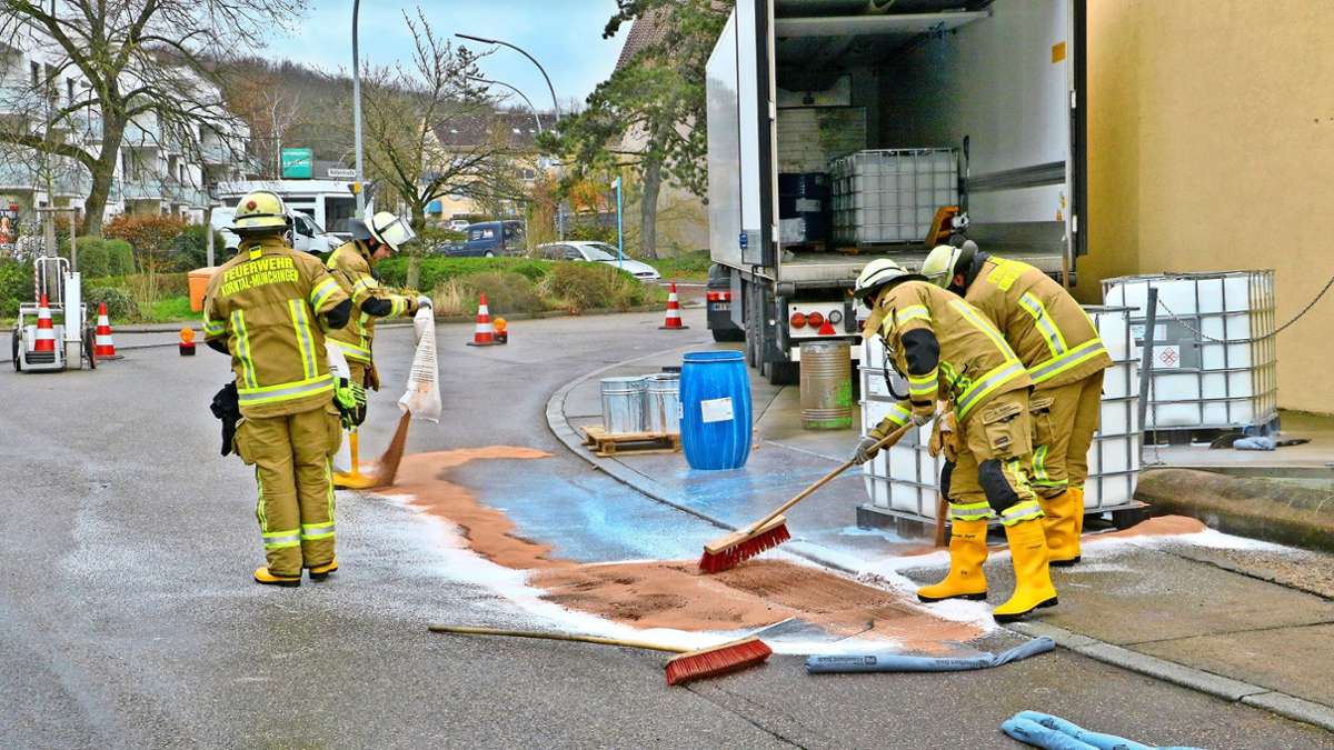 Die Feuerwehr streut die ausgelaufene Flüssigkeit mit Besen und einem Ölbindemittel ab.
