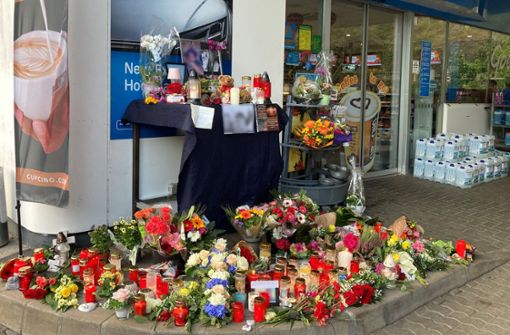 Blumen und Kerzen wurden vor der Tankstelle aufgestellt. Foto: dpa/Birgit Reichert